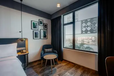 a hotel room with a bed and a chair and a window at Hilton Garden Inn Casablanca Sud in Casablanca