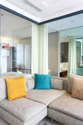 a living room with a couch with yellow and blue pillows at Tantan golden 5 not far from beach in Casablanca