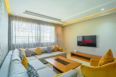 a living room with a couch and a tv at Massira Diamond Maarif- Parking-wifi-self check in in Casablanca