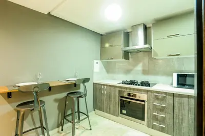 a kitchen with a counter and stools in it at Royal Massira flat in shopping center#wifi#parking in Casablanca