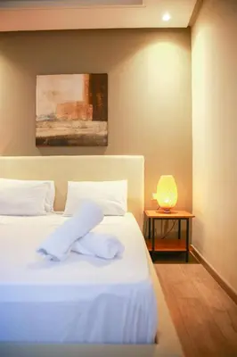 a bedroom with a white bed and a table with a lamp at Royal Massira flat in shopping center#wifi#parking in Casablanca