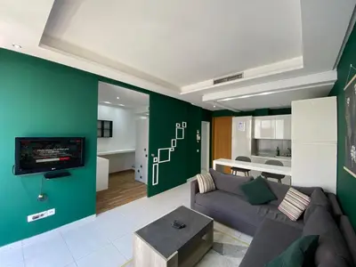 a living room with a couch and a tv at GREEN HOUSE OVERLOOKING INTERNATIONAL SCHOOL in Casablanca
