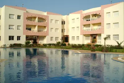 a swimming pool in front of two apartment buildings at Les vagues douces de Mohammedia in Mohammedia
