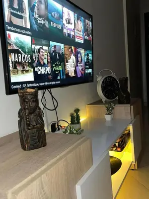 a flat screen tv sitting on top of a entertainment center at Lovely 1-Bed Apartment in Skhirat in Skhirat