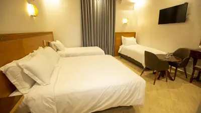 a hotel room with two beds and a table at Hotel de paris in Casablanca