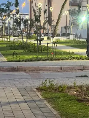 a park at night with lights on a sidewalk at PERLA NOUACEUR AéROPORT MOHAMMED V in Nouaceur