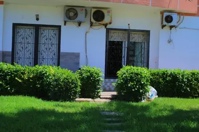 a house with two doors and bushes in the grass at MOHAMMEDIA 304 in Mohammedia