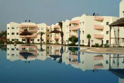 a reflection of buildings in a pool of water at Appartement sable et soleil in Mohammedia