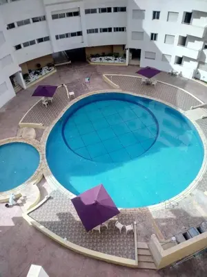 an overhead view of two large pools with umbrellas at Bouznika Centre ville in Bouznika