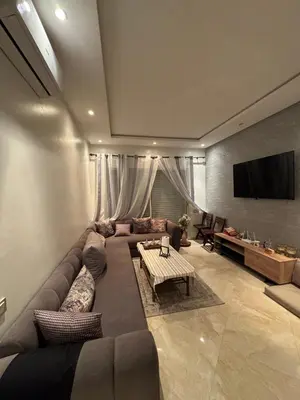 a living room with a large couch and a tv at CASA BAY BEACH OMK in Sidi Rahal