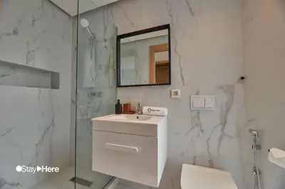 a white bathroom with a sink and a mirror at Stayhere Casablanca - Palmier - Executive Residence in Casablanca