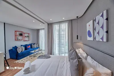 a bedroom with a bed and a blue couch at Stayhere Casablanca - Palmier - Executive Residence in Casablanca
