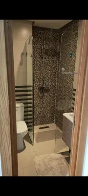 a bathroom with a glass shower and a toilet at bouzkina Costa beach golf in Bouznika