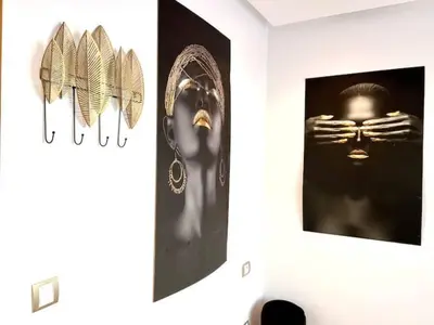 a wall with two pictures of a mask and feathers at Anfa Living 29-The Gatsby 5 Chic&New Apt near Sea in Casablanca