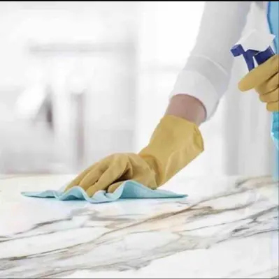 a person wearing gloves wiping a table with a cloth at Anfa Living 29-The Gatsby 5 Chic&New Apt near Sea in Casablanca
