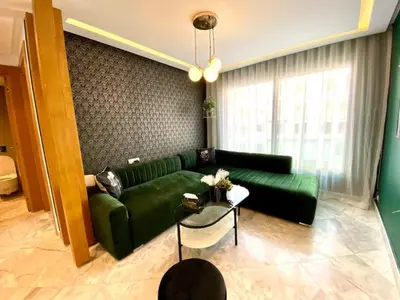 a living room with a green couch and a table at Anfa Living 29-The Gatsby 5 Chic&New Apt near Sea in Casablanca