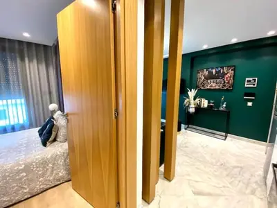a room with a bed and a green wall at Anfa Living 29-The Gatsby 5 Chic&New Apt near Sea in Casablanca