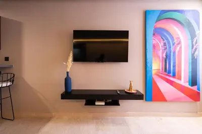 a living room with a tv and a painting on the wall at Luxoria by ShortStayMaroc, Studio Moderne et Chic, Parking, Quartier Central in Casablanca