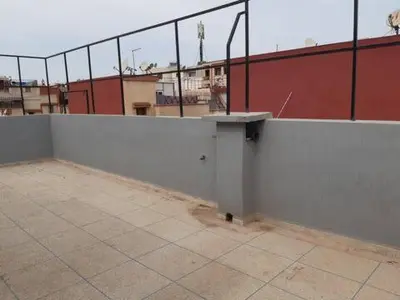a white wall on top of a tennis court at Les Appartements de Massira in Temara