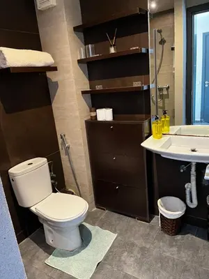 a bathroom with a toilet and a sink at Appartement front de mer avec piscine en face des plages privées in Dar Bouazza