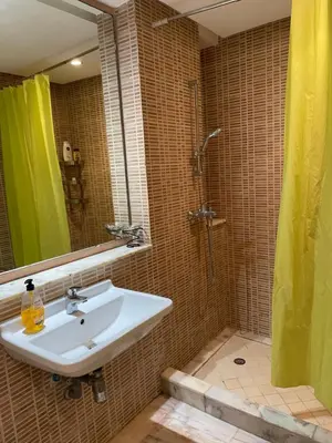 a bathroom with a sink and a shower with a mirror at Airport to Comme à la maison 2 in Derroua