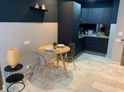 a table and chairs in a kitchen with blue cabinets at Luxurious Appart near tramway #fibre optique in Casablanca