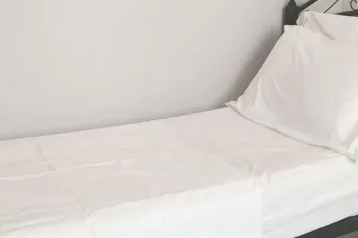 a white bed with white sheets and pillows at Grand Appartement à 5 min de la mer et de la mosqué hassan II de Casablanca in Casablanca