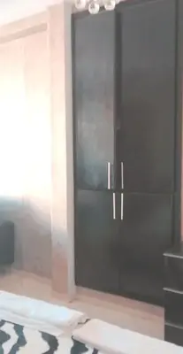 a black cabinet in a room with a rug at Grand Appartement à 5 min de la mer et de la mosqué hassan II de Casablanca in Casablanca