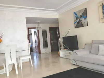 a living room with a white couch and a tv at Grand Appartement à 5 min de la mer et de la mosqué hassan II de Casablanca in Casablanca