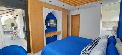 a bedroom with a blue bed and a kitchen at RABAT Residence - OCEAN STAY in Rabat