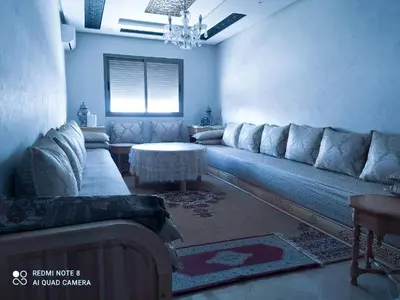 a living room with a couch and a table at Appartement à Bouznika prêt du plage Dahomey, plage bouznika, Bahia beach in Bouznika