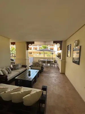 a living room with couches and a table and chairs at Havre de paix au BahiaGolf Beach, Résidence Front Mer in Bouznika
