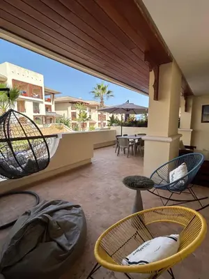 a patio with chairs and tables on a balcony at Havre de paix au BahiaGolf Beach, Résidence Front Mer in Bouznika