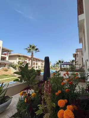 a garden with flowers in front of a building at Havre de paix au BahiaGolf Beach, Résidence Front Mer in Bouznika