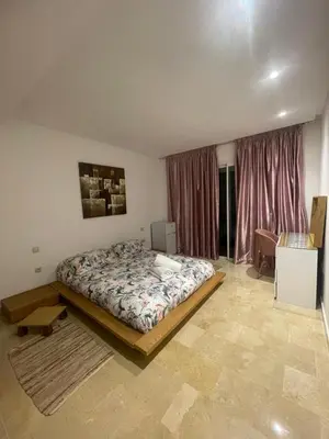 a bedroom with a bed and a desk in it at Havre de paix au BahiaGolf Beach, Résidence Front Mer in Bouznika