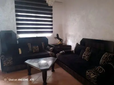 a living room with a couch and a table at Villa avec piscine privée près de Casablanca Maroc in Dar Bouazza