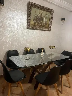a dining room with a table and black chairs at Villa avec piscine privée près de Casablanca Maroc in Dar Bouazza
