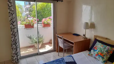 a bedroom with a bed and a desk and a window at Adarissa House in Rabat