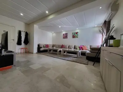 a living room with a couch and a tv at Luxury Spacious Apartment Midtown Casablanca in Casablanca