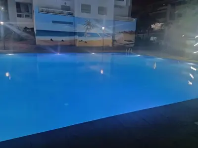 a large swimming pool at night with blue lights at Appartement la Siesta beach resort Mohammedia in Mohammedia