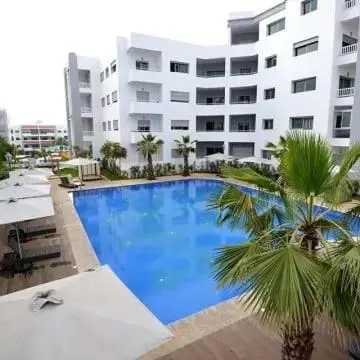 a large swimming pool in front of a large building at Appartement la Siesta beach resort Mohammedia in Mohammedia