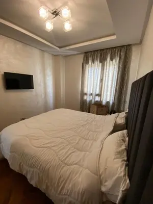 a bedroom with a white bed with a ceiling fan at Casa finance city apartment in Casablanca