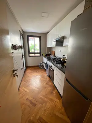 a kitchen with white appliances and a wooden floor at Casa finance city apartment in Casablanca