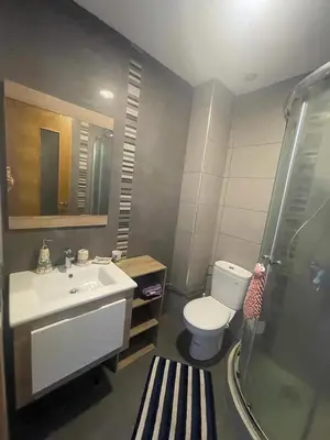a bathroom with a toilet and a sink and a shower at Superbe appartement en résidence avec piscine in Sidi Rahal
