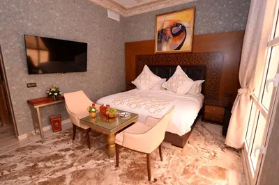 a bedroom with a bed and a table with chairs at THE WHITE PALACE Rabat in Rabat