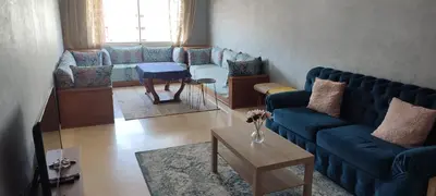 a living room with blue couches and a table at Appartement Résidence fermée in Casablanca