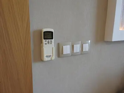 a cell phone hanging on a wall next to a lightswitch at Anfa Place, Art Deco Luxury Apartment, Sunny Ocean View in Casablanca