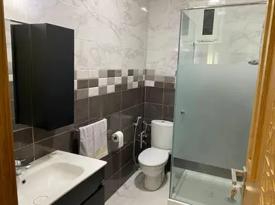 a bathroom with a toilet and a sink and a shower at Lovely 4-bedroom condo with pool in Rabat