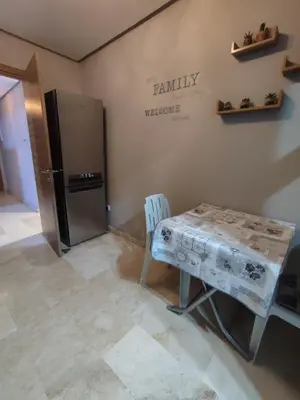 a kitchen with a table and a refrigerator at LUXURY 3 bedroom apartment with pool, Nouaceur, Morocco in Derroua