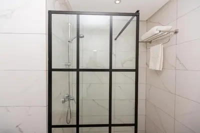 a shower with a glass door in a bathroom at Airport Apartment Suite Casablanca FREE WIFI Modern Confort Calme in Derroua